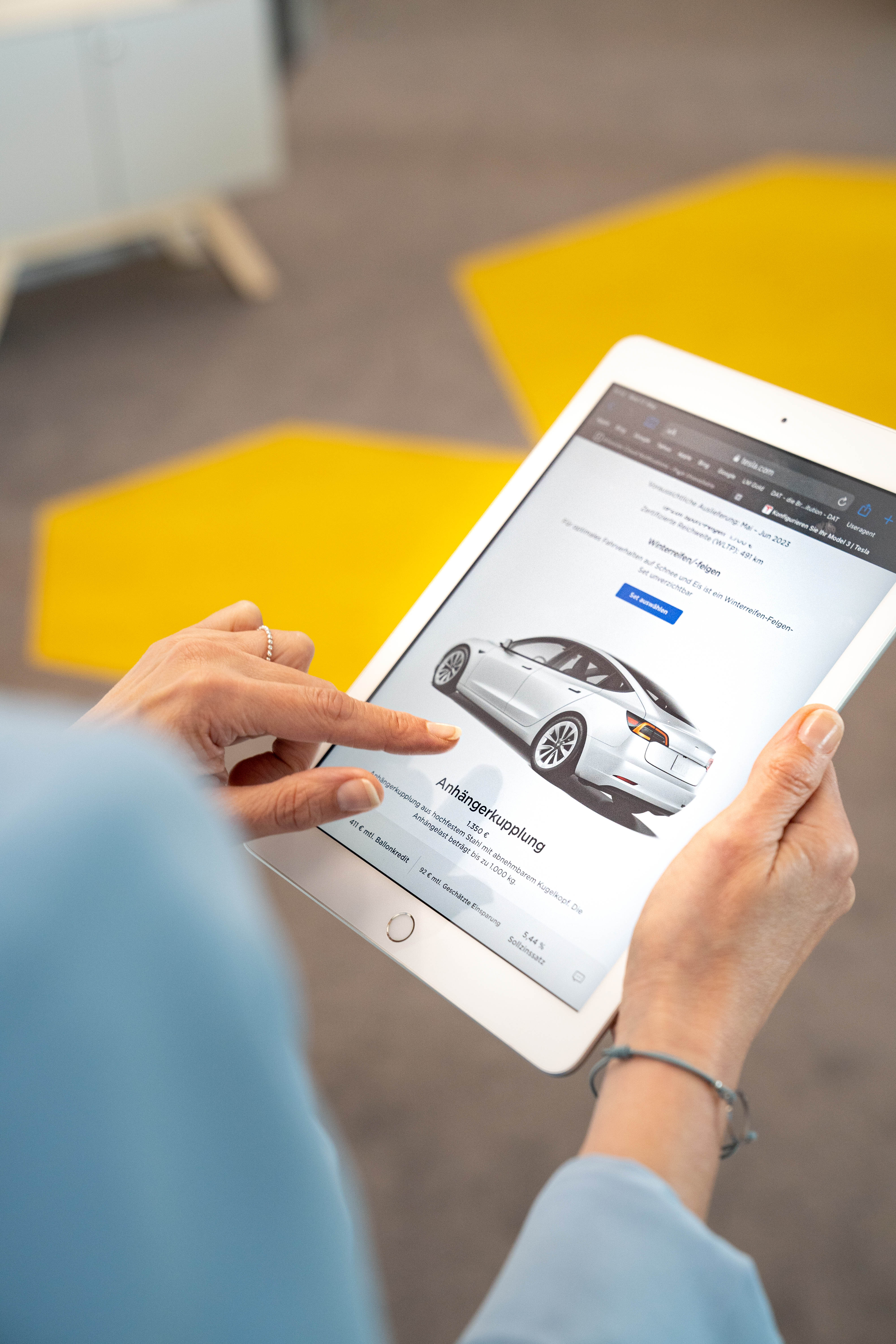 Tablet mit Ansicht des Tesla-Konfigurators: Wohin führt die Preisentwicklung auf dem E-Auto-Gebrauchtwagenmarkt?